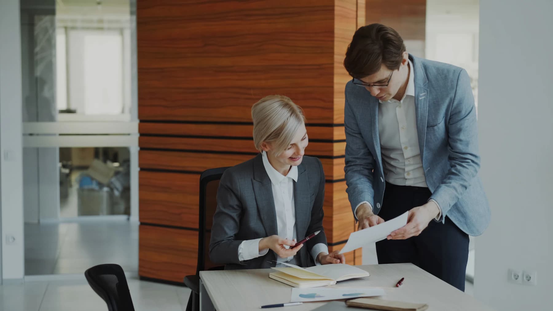 Two professionals reviewing documents at an office desk